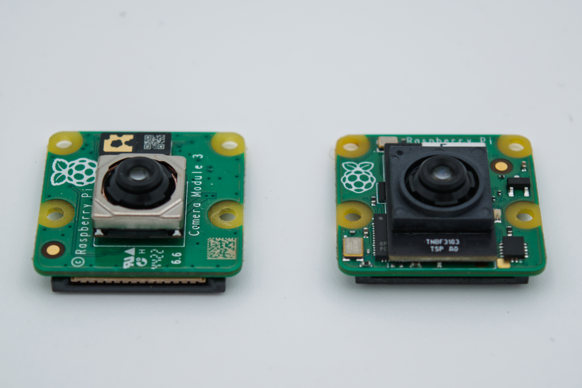 A photo showing the Raspberry Pi Camera Module 3 on the left and the Raspberry Pi AI Camera on the right, highlighting their similar size and format.