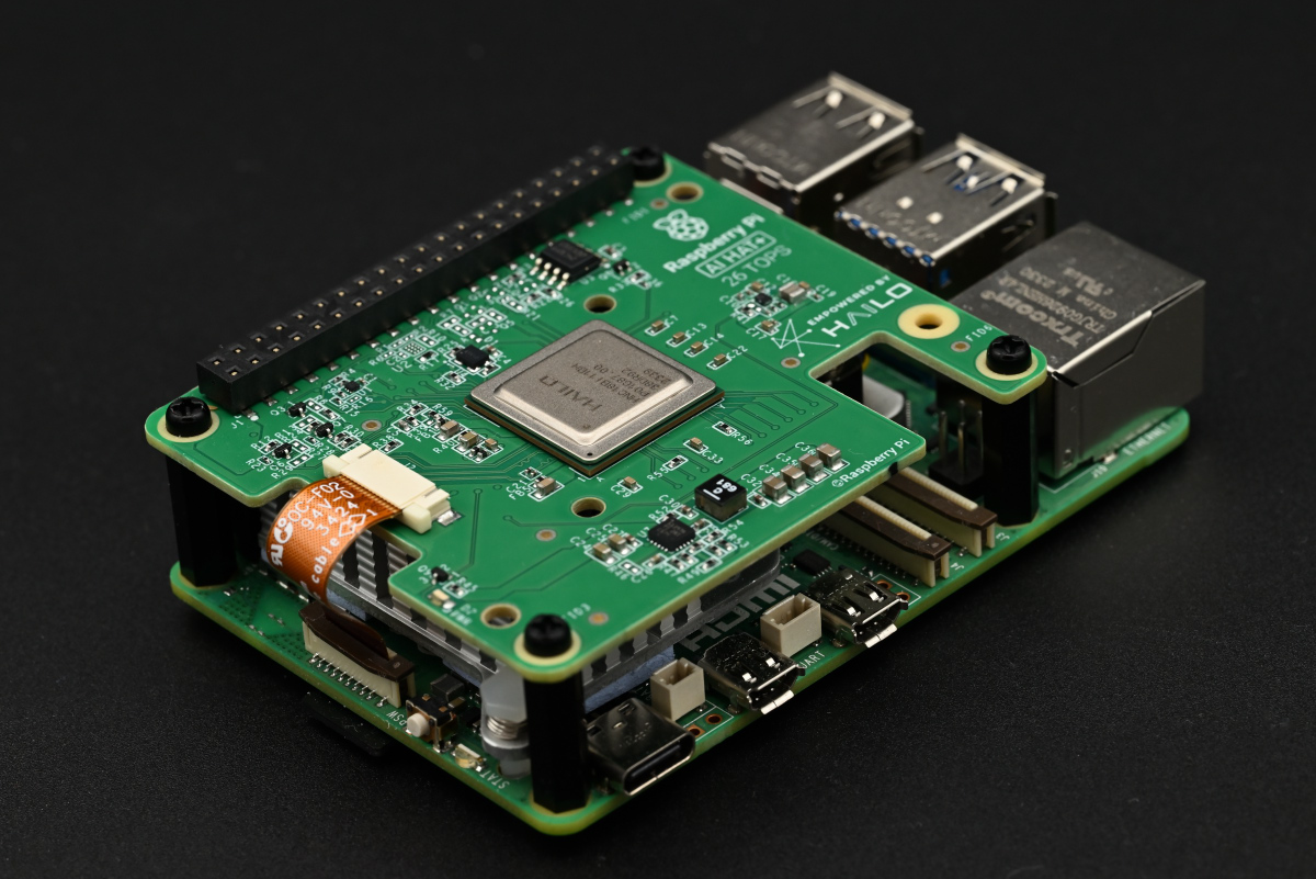 An alternate shot of the AI HAT+ mounted on the Raspberry Pi 5, clearly showing the PCIe cable.