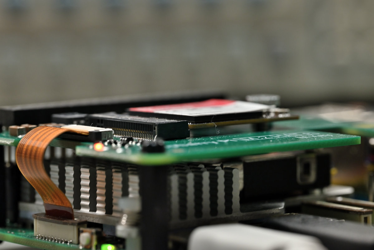 A side-photo of a 256 GB Raspberry Pi SSD mounted on top of the Raspberry Pi M.2 HAT+.