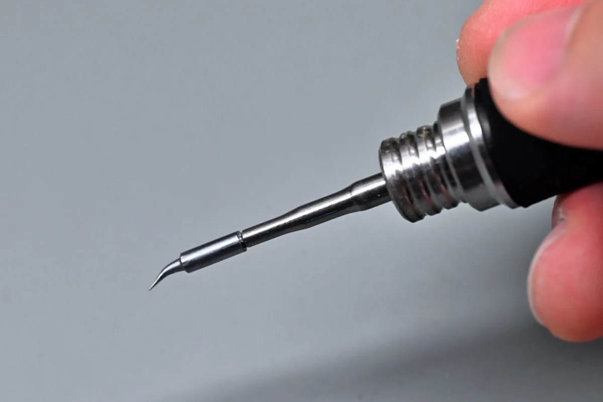 A photo showing the TS21 being held with a brand-new bent conical tip mounted.