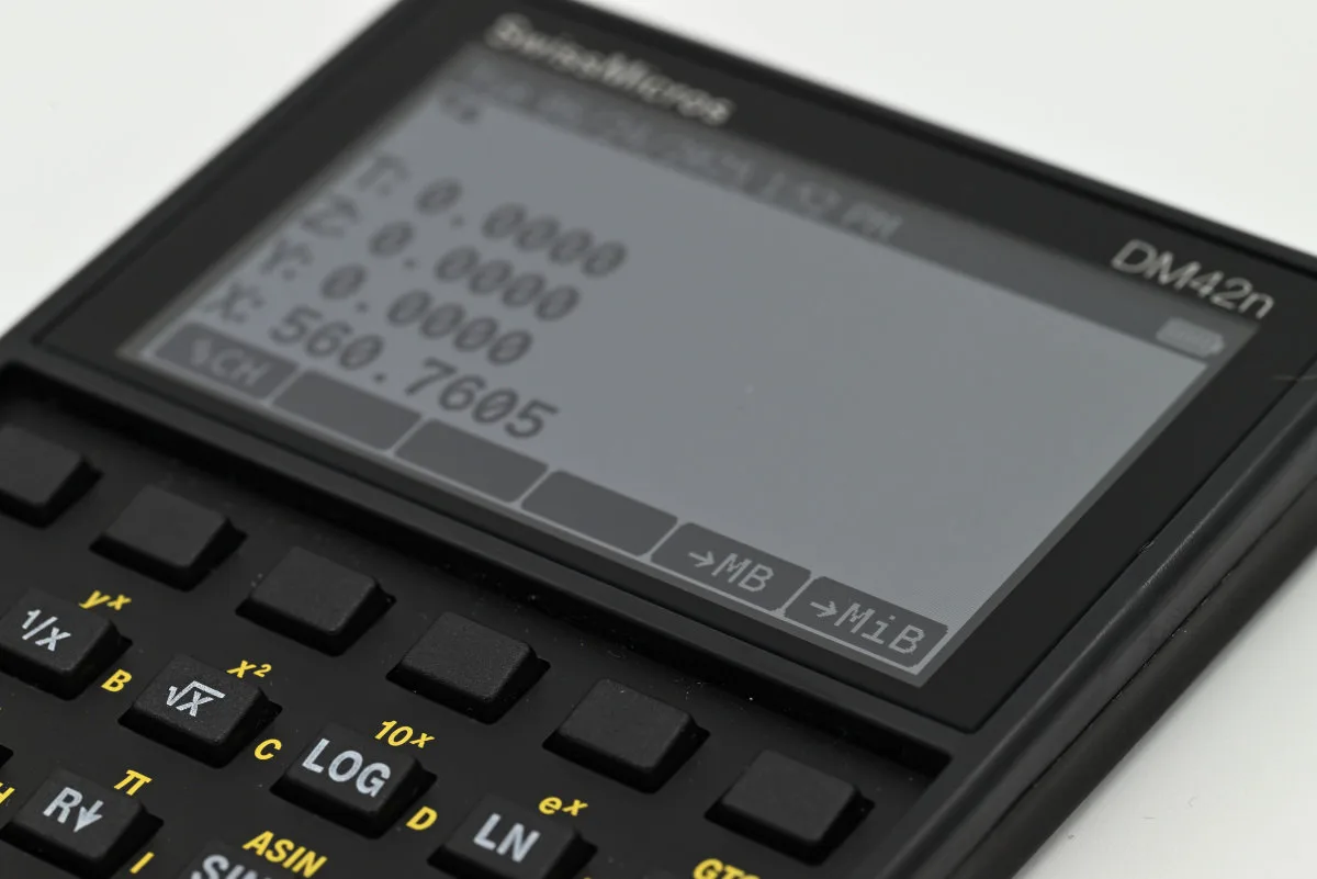 A photo of the calculator's screen showcasing the custom menu, with the built-in %CH command assigned to the far-left field and two custom programs assigned to the final two fields.