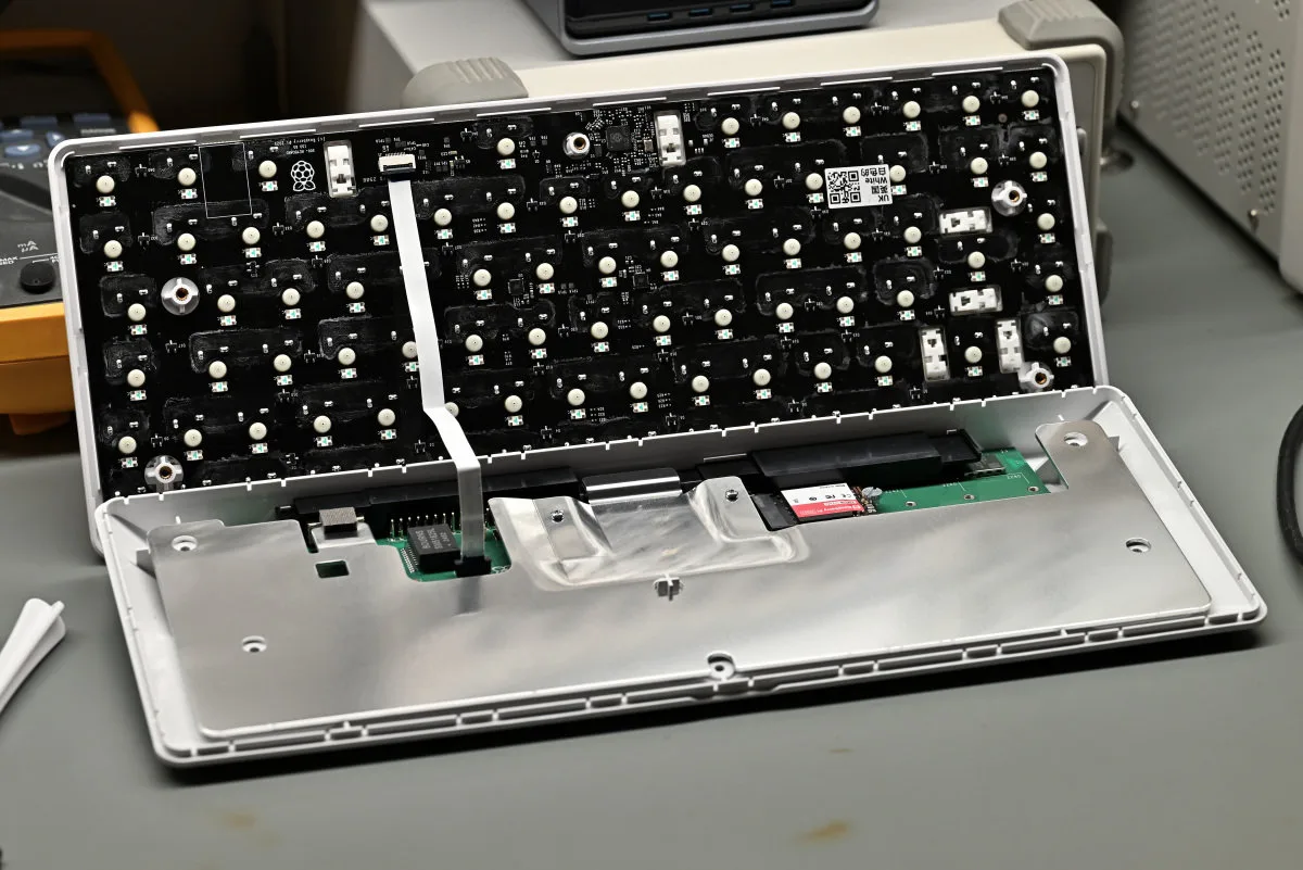 A photo showing the Raspberry Pi 500+ open, with the keyboard still attached with its ZIF ribbon cable.