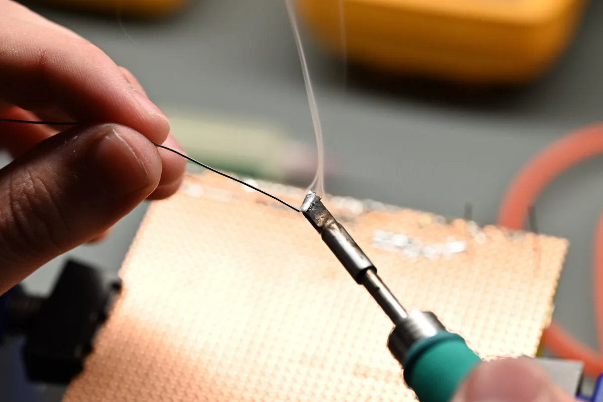 A photo of the C245 handle melting a bit of rosin-core solder, with a smoke plume showing.