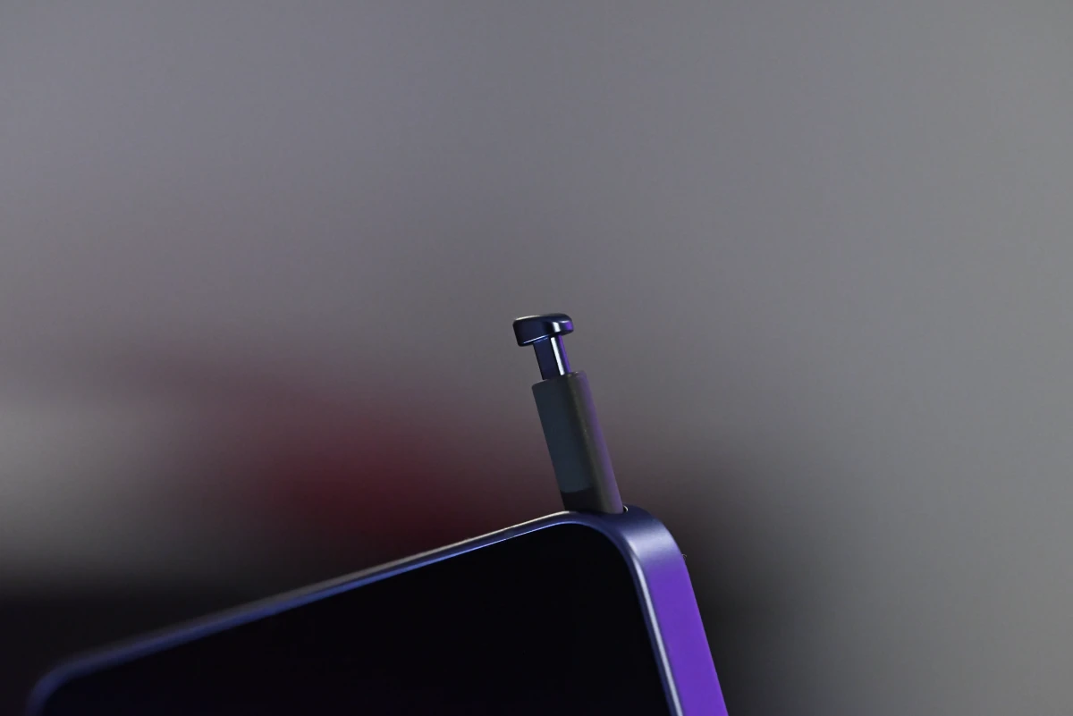 A photo of the S Pen slightly removed from the phone's frame, showing the shape of its retractable top and relative thickness of the stylus.